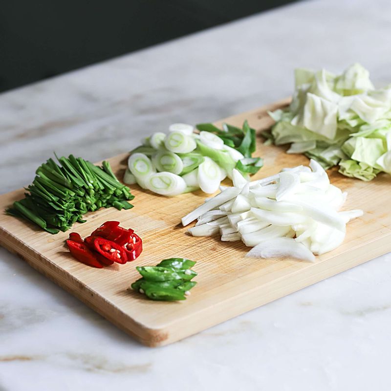 양배추는 사방 3센치 크기로 썰어두고, 양파는 채썰고. 대파와 청홍고추는 어슷하게 썰어주세요. 부추는 4cm길이로 썰어주세요.