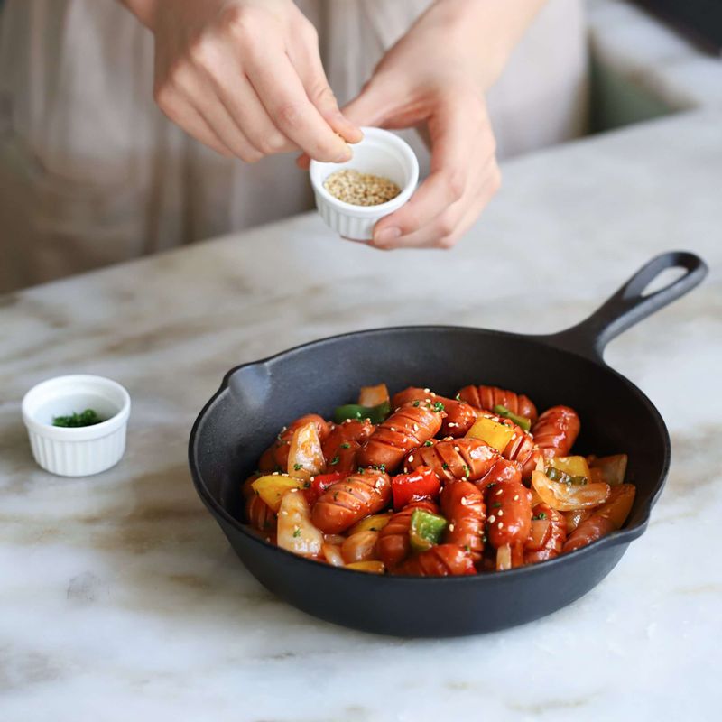 접시에 소시지야채볶음을 담고, 통깨와 다진 파슬리를 뿌려 마무리해주세요.