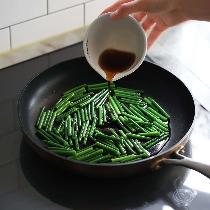 별도의 달군 팬에 오일을 두르고 마늘종을 넣어 1분간 볶다가 양념재료를 넣어 약 2~3분간 더 볶아주세요.