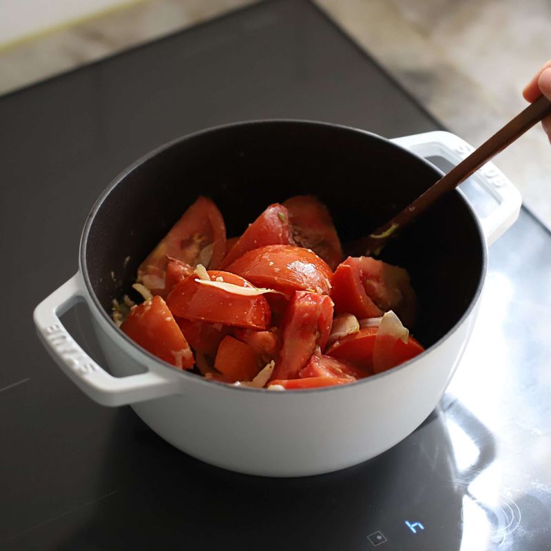 토마토와 당근을 넣어 3~4분 볶다가 뜨거운 물에 치킨스톡을 넣어 녹이고, 월계수잎과 바질가루를 함께 넣어 주세요. 중약불에서 뭉근하게 10~15분 끓인 후, 불을 끄고 월계수잎을 건져주세요.