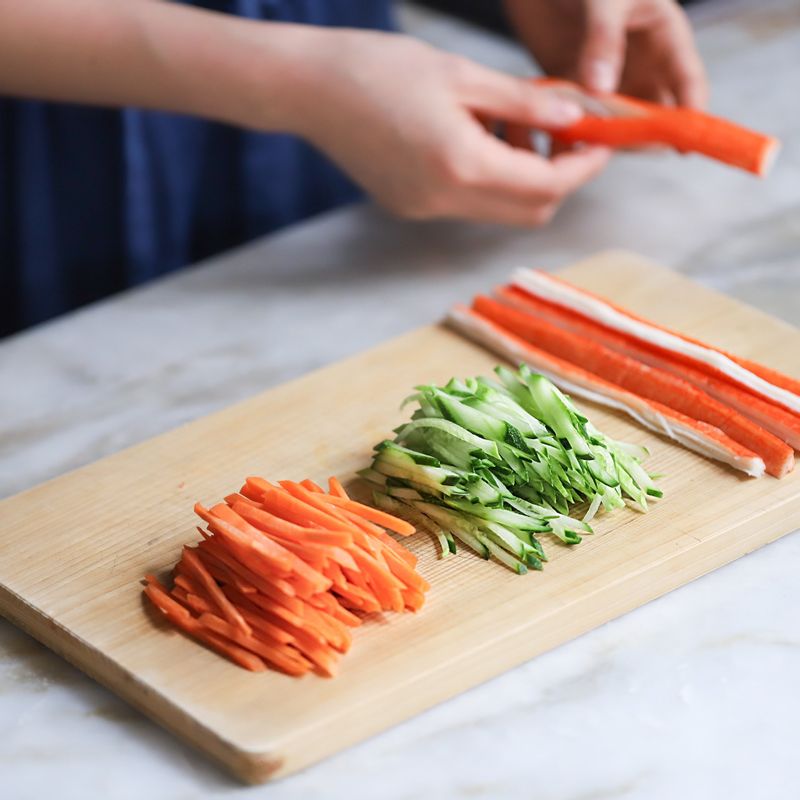 깨끗이 씻은 우엉과 당근은 껍질을 벗겨낸 후 가늘게 채썰고, 오이도 채썰어주세요. 맛살은 길게 반으로 잘라주세요.
(Tip. 우엉을 식촛물에 1~2시간 담궈두면 우엉의 아린맛을 제거할 수 있어요. 담궈둔 우엉은 찬물에 헹군 후 조리해주세요.)