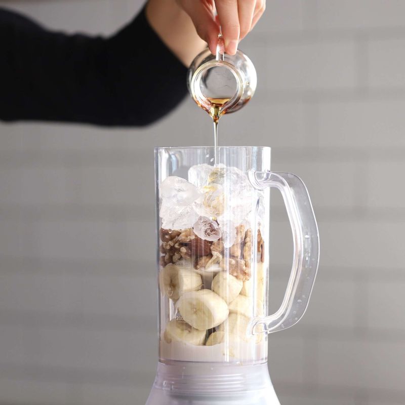 블렌더에 바나나와 연두부, 아몬드, 호두, 코코아닙스, 아몬드밀크, 시나몬파우더, 얼음, 메이플시럽을 넣고 갈아주세요.