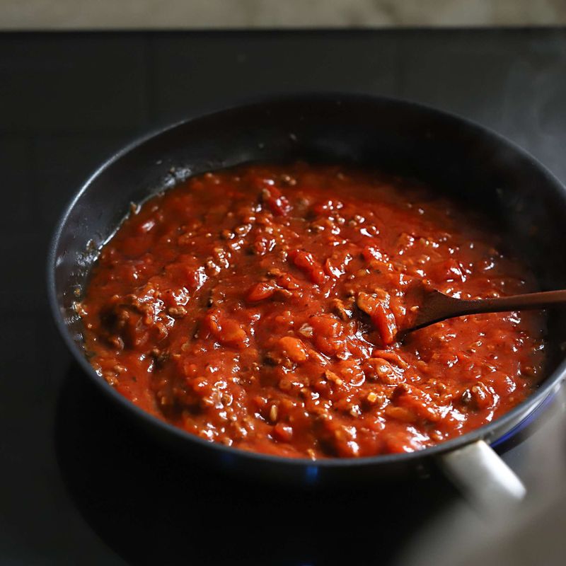 쇠고기가 익으면 토마토소스를 넣고 볶다가 볶은 가지와 방울 토마토, 삶은 파스타면을 넣어주세요. 면수를 넣어 농도를 조절한 후 소금과 후춧가루를 넣어 간을 해주세요.