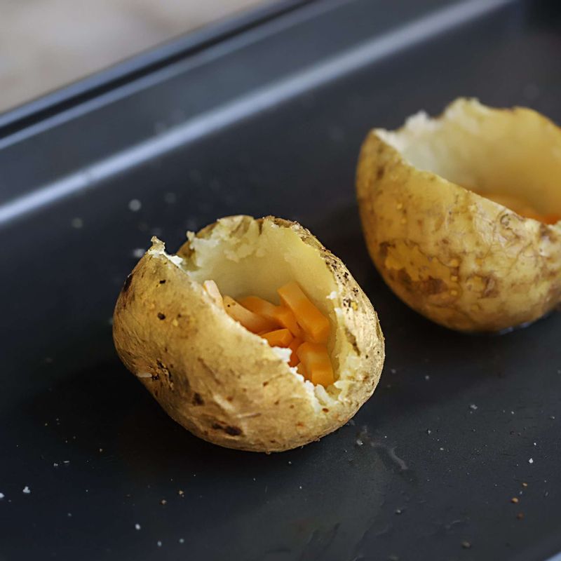 속을 파낸 감자에 콜비잭치즈를 담고, 섞은 속을 채워 넣어주세요. 윗부분에 콜비잭치즈와 실파를 뿌려 180도로 예열 된 오븐에서 10분간 노릇하게 구워주세요.