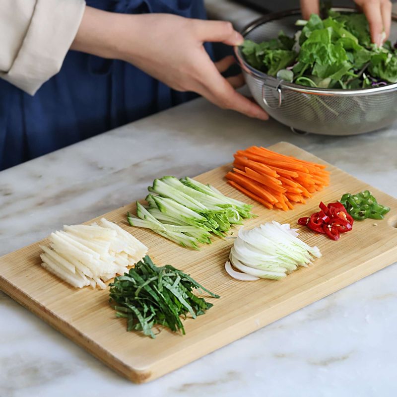 오이와 당근, 양파는 얇게 채썰어주세요. 깻잎도 적당한 길이로 채썰고, 청홍고추는 송송 썰어주세요. 배는 껍질을 벗긴 후 채썰어주세요. 어린잎채소와 무순은 깨끗이 씻어 체에 밭쳐주세요.