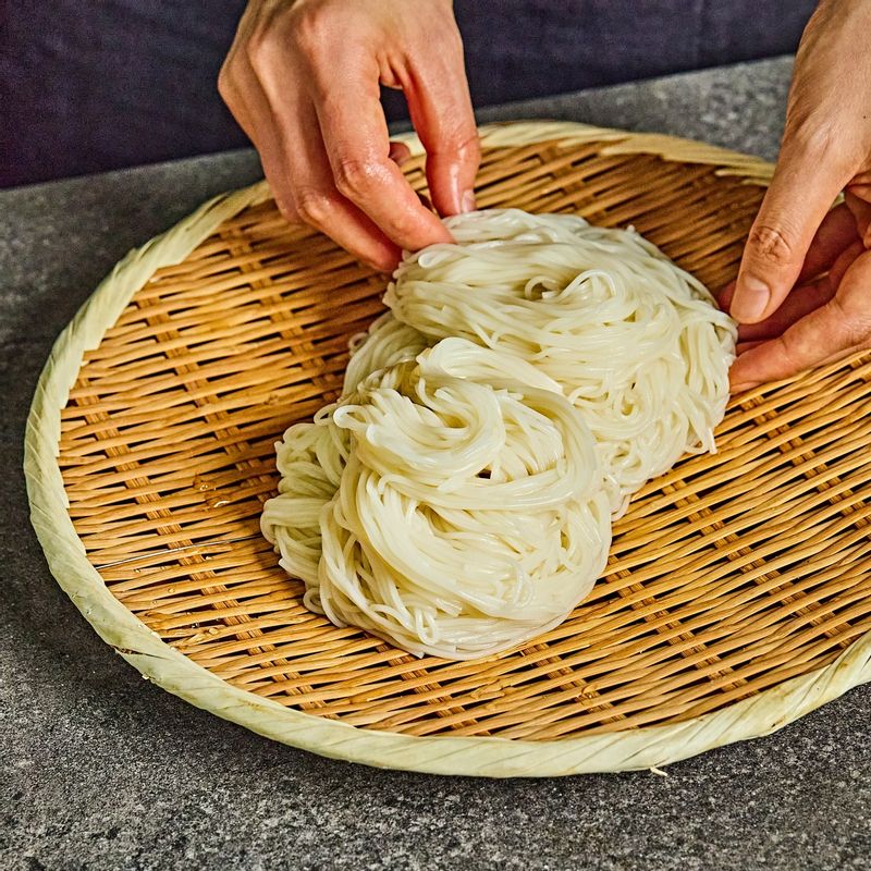 흐르는 찬물에 소면을 여러 번 씻어 전분기를 없애고, 돌돌 말아 채반에 밭쳐 물기를 빼 주세요.