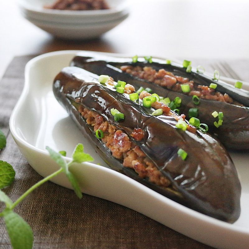 팬에 기름을 두르고 굴소스와 가지를 넣고 뚜껑을 덮은 후 앞뒤로 한 번씩 뒤집어서 익혀주세요. 가지가 익으면 그릇에 담고 송송 썬 실파를 뿌려주세요.