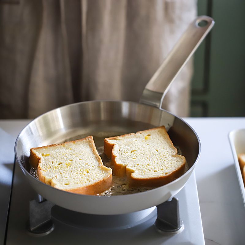 달군팬에 버터를 두르고 빵을 올려 약불에서 3~5분간 익혀주세요. 더 달콤한 프렌치토스트를 원하신다면 빵 양쪽에 설탕을 뿌려주세요.