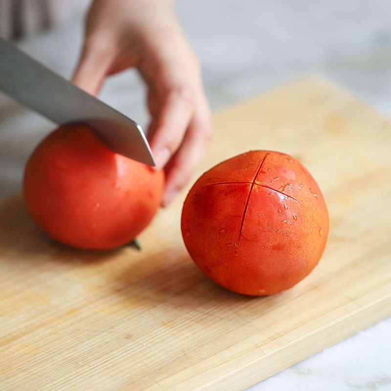 토마토는 꼭지를 떼고 칼집을 낸 후, 끓는 물에 소금을 넣고 1~2분 정도 데쳐 차가운 물에 담가 껍질을 벗겨주세요. 껍질을 벗긴 토마토는 웨지모양으로 8등분 해주세요.