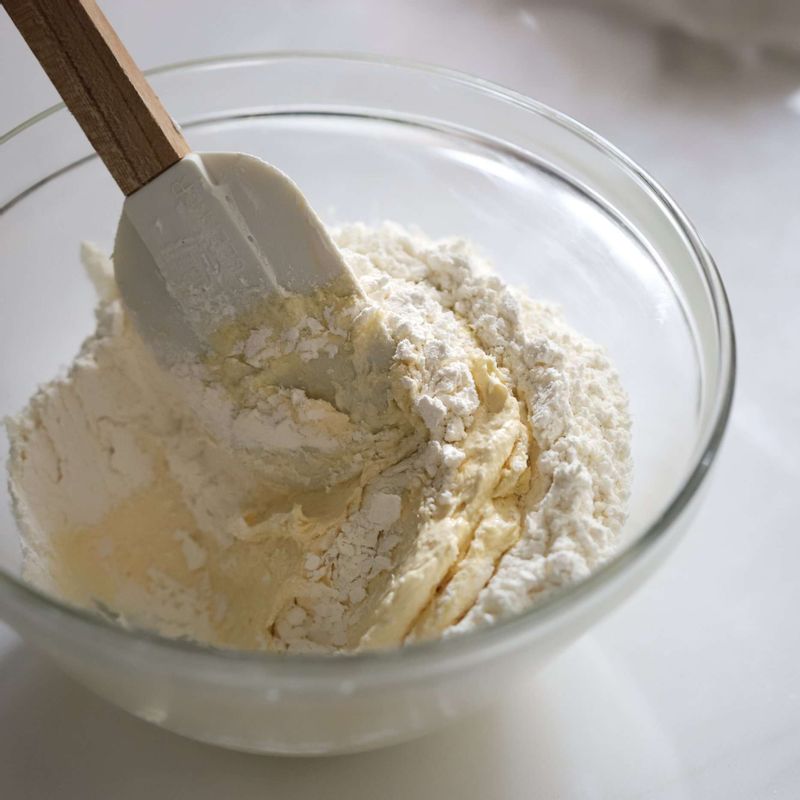 체 친 박력분과 베이킹파우더를 넣어 가볍게 섞어주세요. 너무 오래 섞으면 머핀이 질겨질 수 있으니, 가볍게 섞어준 후 우유를 넣어 잘 섞어주세요.