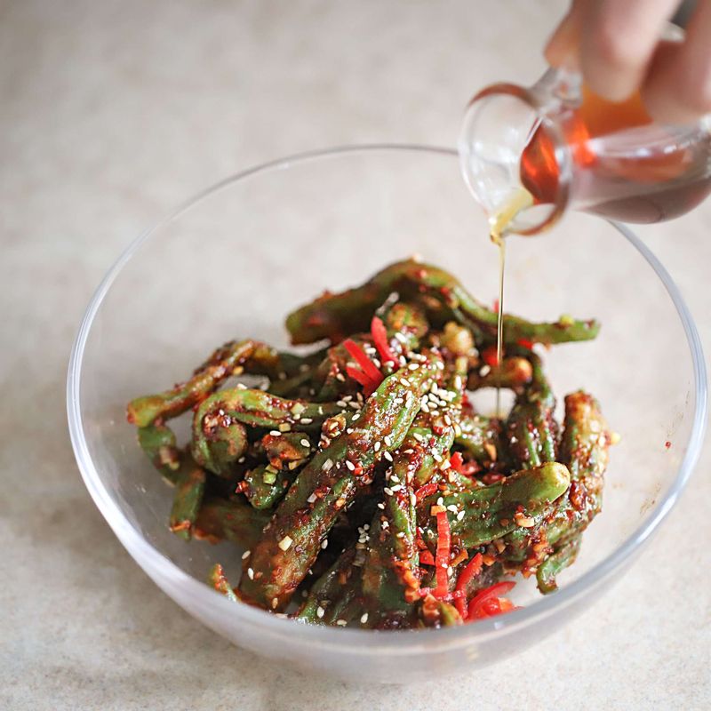 찐 꽈리고추와 양념, 홍고추를 넣어 골고루 섞은 후 마지막에 참기름과 통깨를 뿌려 완성해주세요.