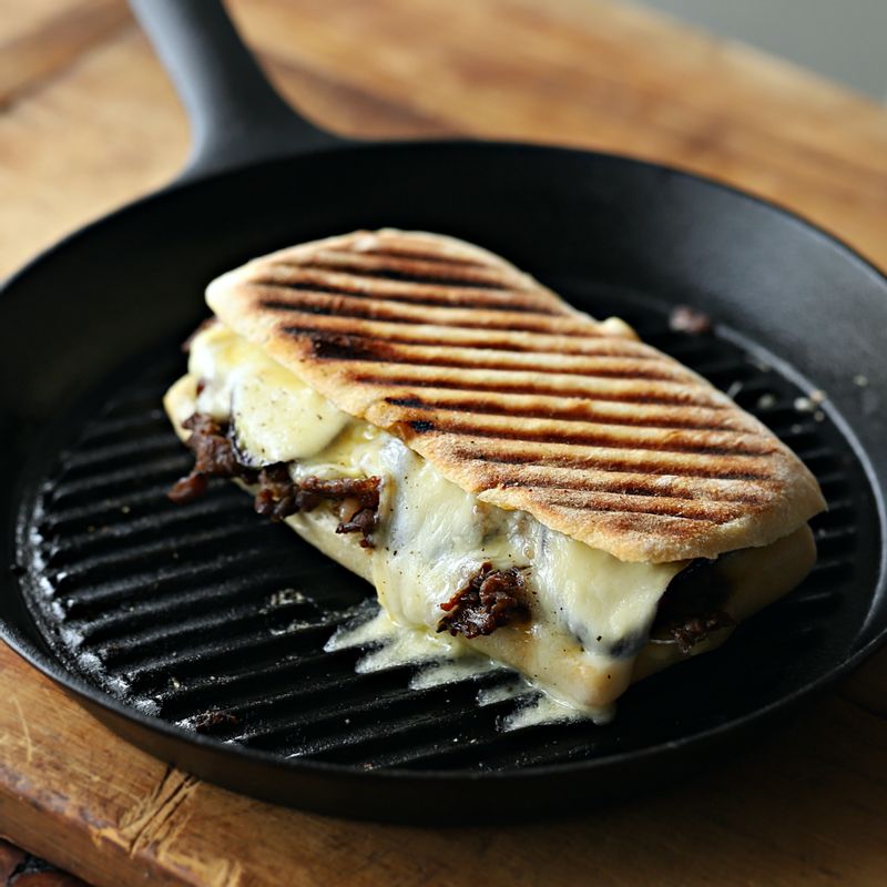 달군 그릴 팬에 파니니를 올리고 무거운 뚜껑이나 냄비로 눌러 약한 불에서 앞뒤로 4분씩 구워주세요. 
(파니니 전용 그릴 팬을 사용하면 편리해요. 치즈가 녹을 때까지 구워주세요)
(기호에 따라 타바스코를 뿌려 먹어도 좋아요)