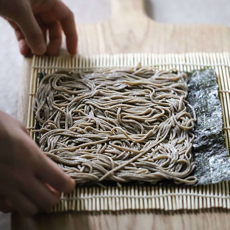 김발에 김밥용 김을 깔고 메밀면을 2/3 정도 얇게 깔아주세요. 오이, 아보카도, 크래미, 달걀말이를 올려 돌돌 말아주세요.