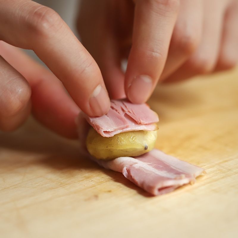 찐 밤은 길게 반으로 접은 베이컨으로 돌돌 말아 꼬치로 고정을 시켜주세요.