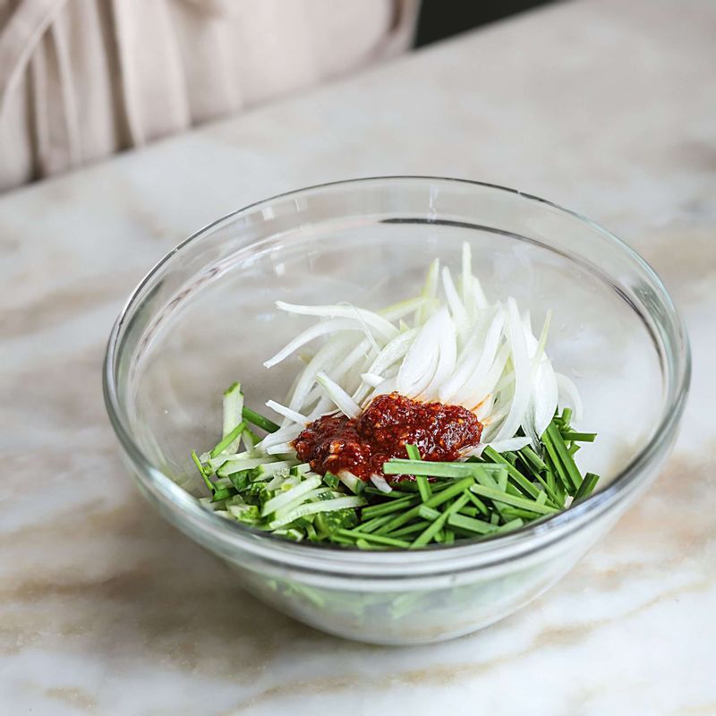 양념장 재료에 준비한 채소와 구운 항정살을 넣어 버무려주세요.