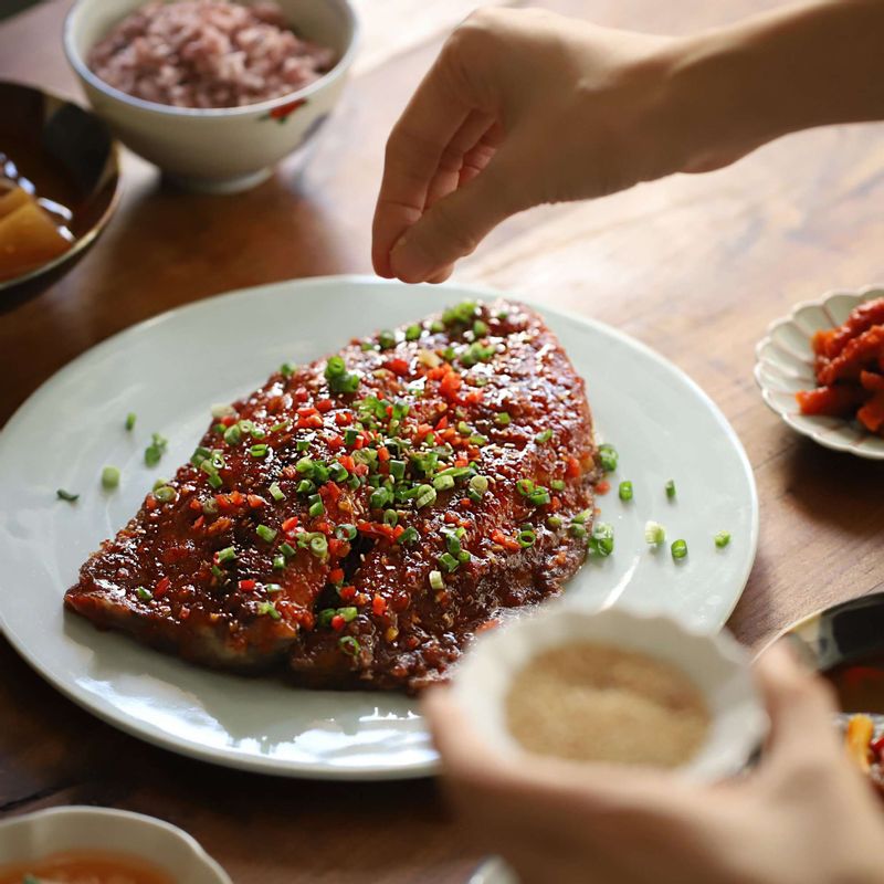 접시에 구운 고등어를 담고 고추장 양념을 추가로 덧바른 후 고추와 실파, 통깨를 뿌려주세요.