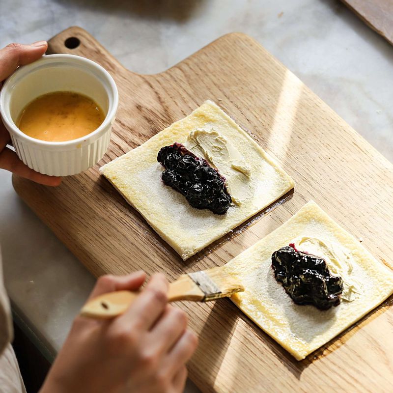 식빵 테두리에 달걀물을 발라 접어주고, 포크로 테두리를 눌러 양쪽 면을 붙인 후 중앙에 칼집을 넣어주세요.