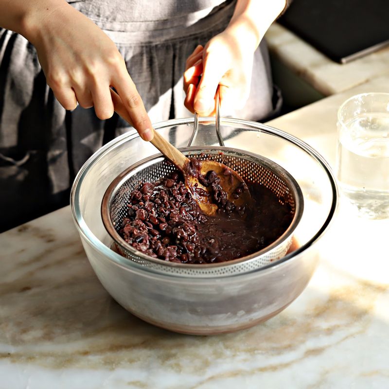 삶은 팥은 뜨거울 때 물 6컵을 조금씩 부어가며 체에 내려 껍질을 거르고 걸러낸 팥물은 10분 정도 두어 팥앙금이 가라앉도록 해주세요.