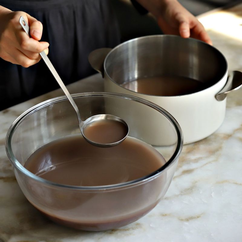 냄비에 팥물의 윗 맑은 팥물만 따라내고 불린 멥쌀을 넣어 쌀알이 퍼질때까지 저어가며 끓여주세요.
(멥쌀을 팥앙금에 처음부터 넣어 끓이면 멥쌀이 잘 퍼지지 않고 앙금이 눌러 붙을 수 있어 멥쌀이 퍼진 후에 넣어 함께 끓여주는 것이 좋답니다.)