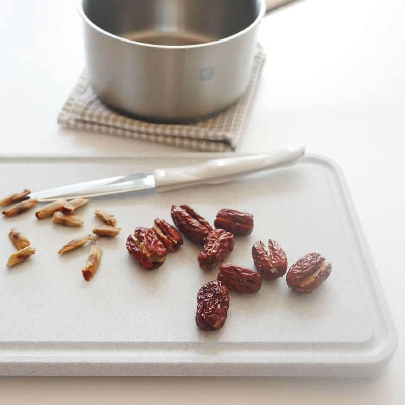 냄비에 물 3컵과 대추 씨를 넣고 중불 이하에서 20~25분간 우려내고 씨를 건져냅니다.
우린 물 2컵에 참기름을 뺀 밥물 재료를 넣고 저어 흑설탕을 녹인 후 참기름을 섞어주세요.