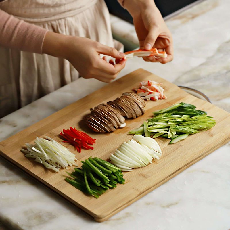 오이는 길이로 4등분하고 씨부분을 포를 떠서 제거하고 어슷하게 얇게 썰어주세요. 피망과 홍고추, 양파, 표고버섯, 대파는 얇게 채를 썰고 크래미는 먹기 좋게 찢어주세요.