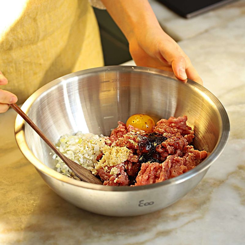 볼에 갈은 돼지고기와 만두소 양념재료, 달걀노른자를 넣고 한 방향으로 돌려가며 섞은 후 다진 야채를 넣어 고루 섞어주세요.