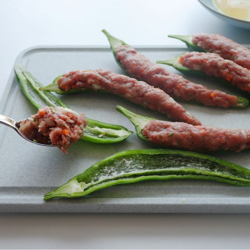 고추 속에 밀가루를 고루 바르고 고기소를 채워주세요. 고추 위에 밀가루를 한 번 더 바르고 달걀물을 입혀주세요.