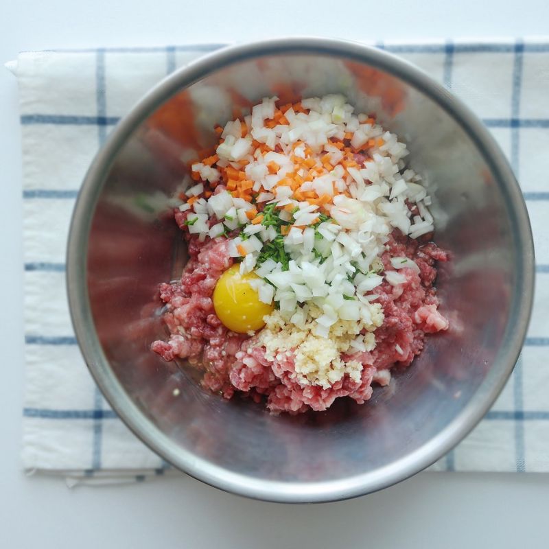 부추, 양파, 당근은 아주 잘게 다져주세요.
볼에 다진 쇠고기, 돼지고기와 다진 부추, 양파, 당근, 양념 재료를 모두 넣은 후 고루 섞으면서 치대어 고기소를 만들어주세요.