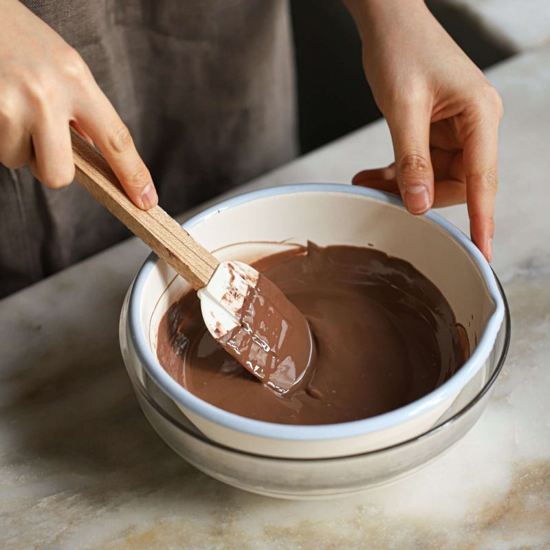 볼에 밀크초콜릿을 담은 후 초콜릿을 담은 볼보다 큰 볼에 60도 이하의 따뜻한 물을 넣고, 저어주며 중탕으로 녹여주세요.