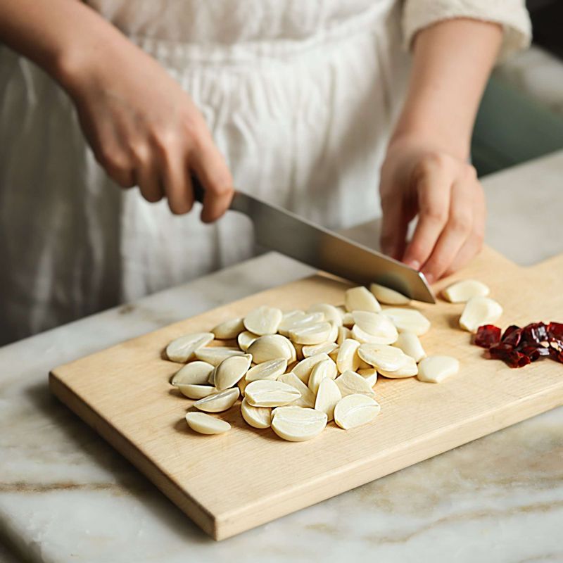 마늘은 꼭지를 도려내고 편으로 이등분한 후 10분정도 찬물에 담갔다가 물기를 제거해주세요. 건고추는 송송 썰어주세요.