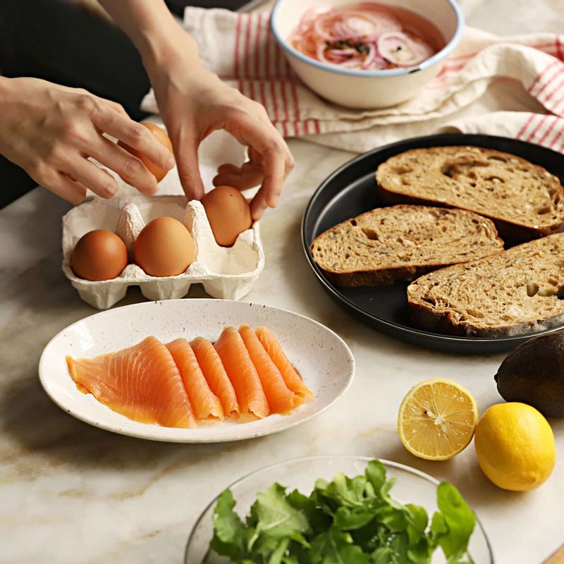 아보카도연어오픈샌드위치을 위한 재료 이미지로 곡물빵,훈제연어 슬라이스,아보카도,적양파 피클,레몬 등으로 구성 되어있습니다.