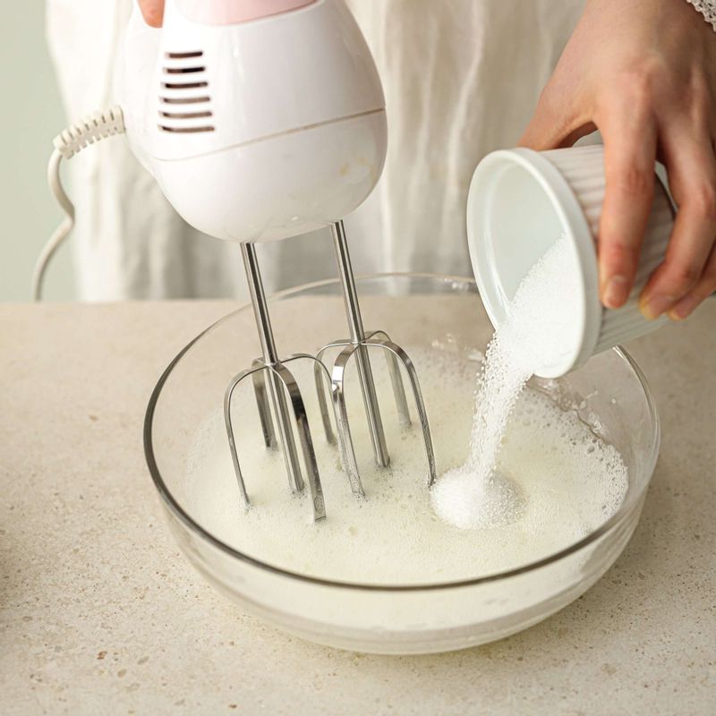 다른 볼에 달걀 흰자를 넣고 거품기로 휘핑하다가 설탕을 2~3번 나누어 넣어 머랭을 80%까지 거품을 올려주세요.