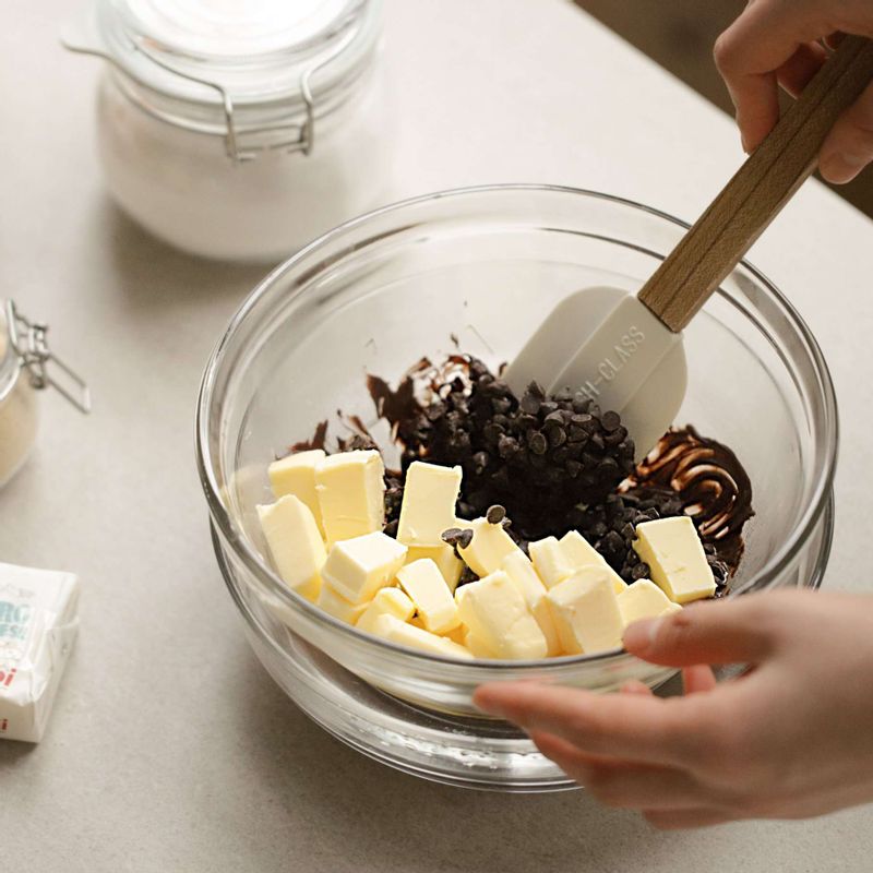 다크 초콜릿과 버터를 볼에 담은 후 초콜릿을 담은 볼 보다 큰 볼에 뜨꺼운 물을 담아 중탕으로 녹여주세요.