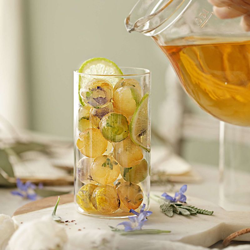 유리잔에 꽃얼음과 슬라이스 라임, 레몬을 넣어주세요. 우려서 식혀 둔 루이보스티를 부어주세요.