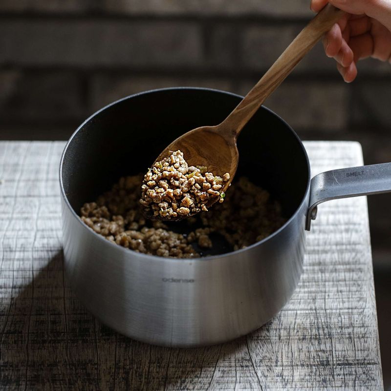 달군 팬에 식용유와 고추기름을 두른 후 대파를 넣고 중약불에서 볶다가 향이 올라오면 밑간한 돼지고기를 넣어 볶아주세요.
