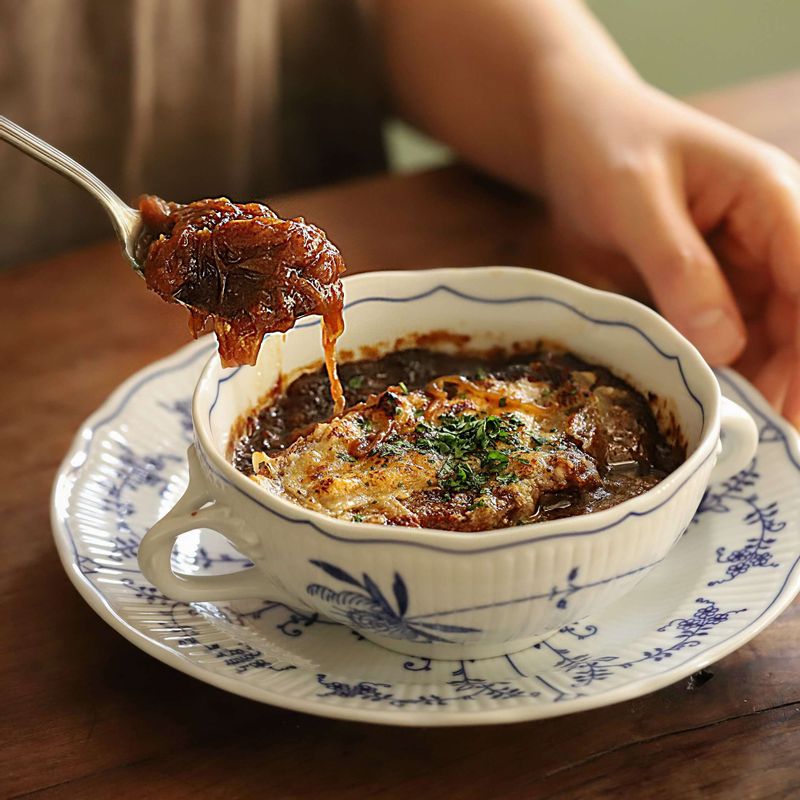 200도로 예열한 오븐에 넣고 치즈가 녹을 때까지 8분 정도 굽고 완성된 양파수프에 파슬리 가루를 뿌려주세요.