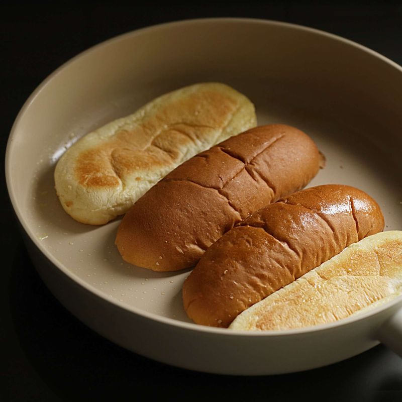 달군 팬에 버터를 바른 후 핫도그 빵을 앞뒤로 노릇하게 구워주세요.