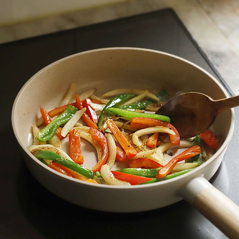 달군 팬에 오일을 두른 후 양파와 피망에 소금, 후춧가루를 뿌리고 중불에서 5분 정도 볶아 그릇에 덜어주세요.