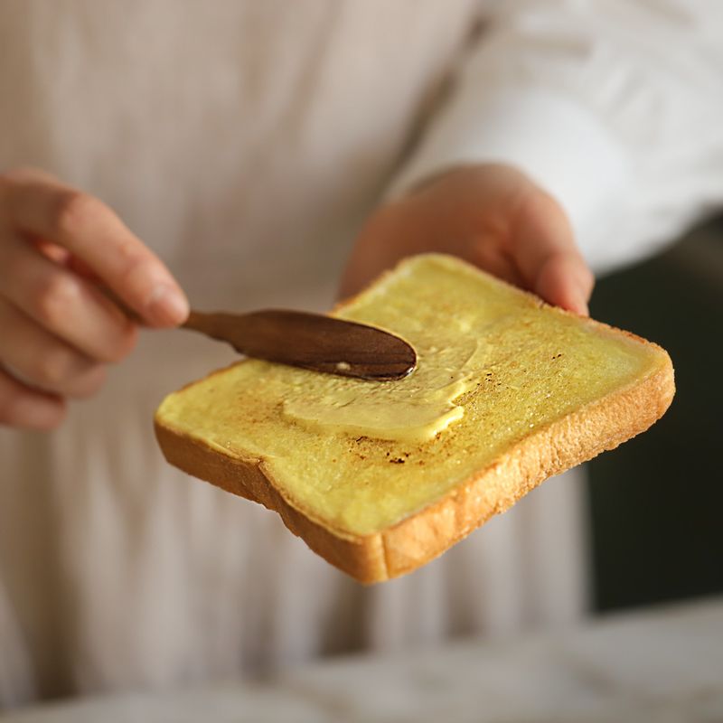 도마에 종이호일을 깔고 빵 한쪽 면에 스프레드를 발라주세요. 으깬 달걀을 적당량 올린 후 삶은 반숙 달걀을 올려주세요. 양배추를 적당량 올린 후 빵으로 가볍게 누른 후 랩이나 종이호일로 단단하게 감싸주세요.