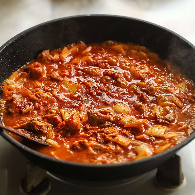 돼지고기가 익으면 남은 양념장과 멸치 다시마 육수를 넣어 끓이고 국물이 자작해지면 구운 두부와 대파, 홍고추, 청양고추를 넣고 양념이 골고루 베이도록 끓여주세요.