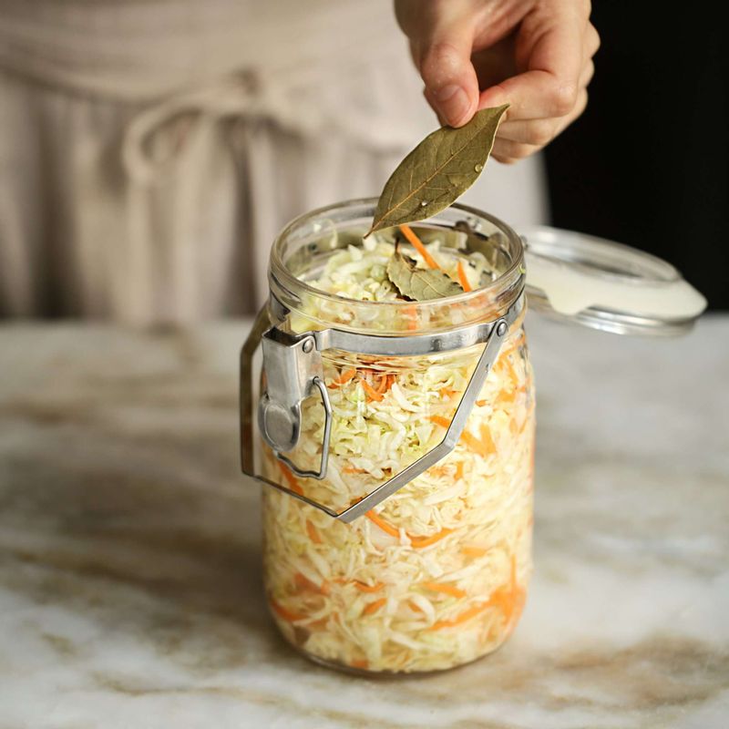 절인 양배추와 당근은 소독한 밀폐 용기에 공기없이 꾹꾹 눌러담고 월계수잎을 올려주세요.(양배추를 절이면서 나온 물도 함께 담고 절인 물에 양배추가 잠기도록 해 주세요.)