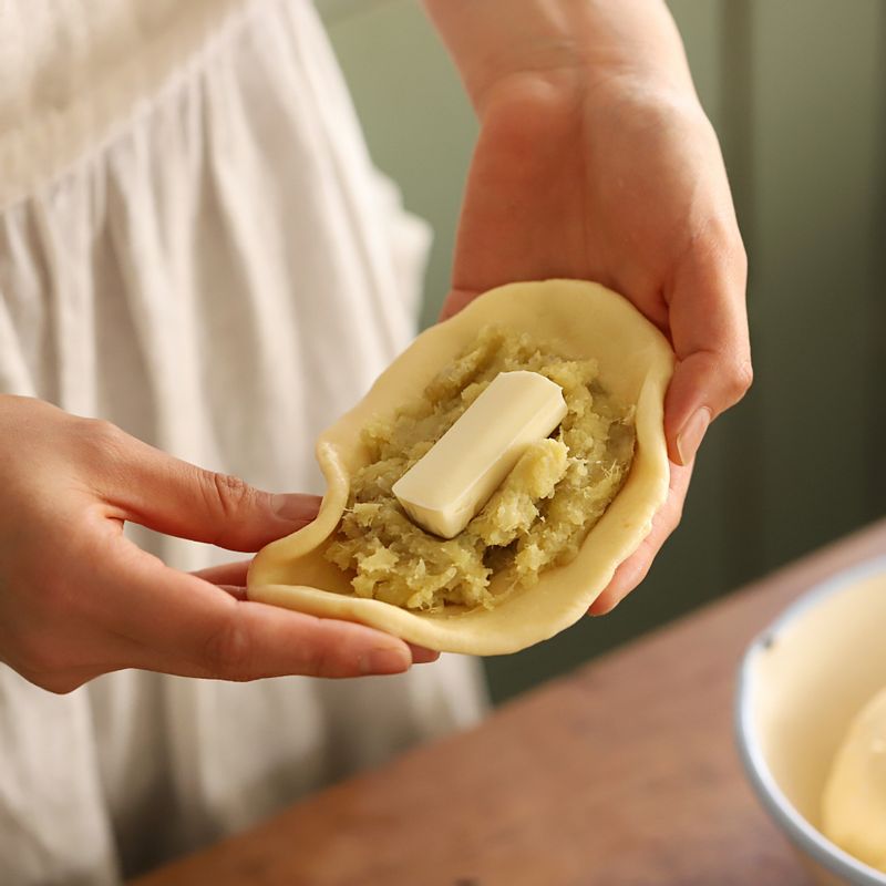 반죽을 적당한 크기로 떼어내 가운데에 으깬 고구마 속 내용물과 스트링 치즈를 넣고 고구마 모양처럼 만들어주세요.