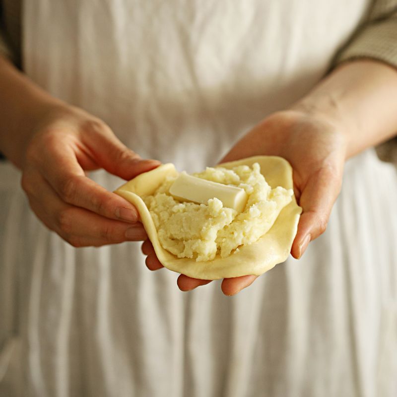 반죽을 적당한 크기로 떼어내 가운데에 으깬 감자 속 내용물과 스트링 치즈를 넣고 동그랗게 만들어주세요.