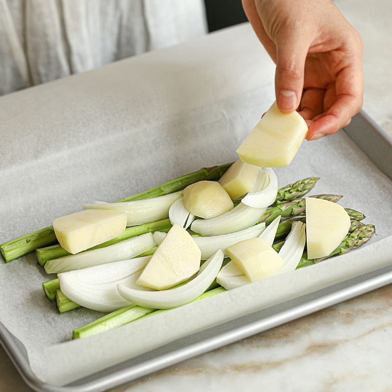 종이호일 위에 감자와 양파, 아스파라거스를 깔고 연어를 올려주세요.