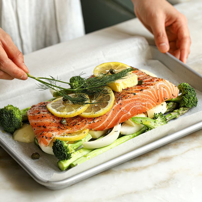 레몬과 딜, 브로콜리, 케이퍼를 올린 후 버터, 소금, 후춧가루를 뿌리고 종이호일로 밀봉하다가 마지막에 화이트와인을 붓고 완전히 밀봉해주세요.