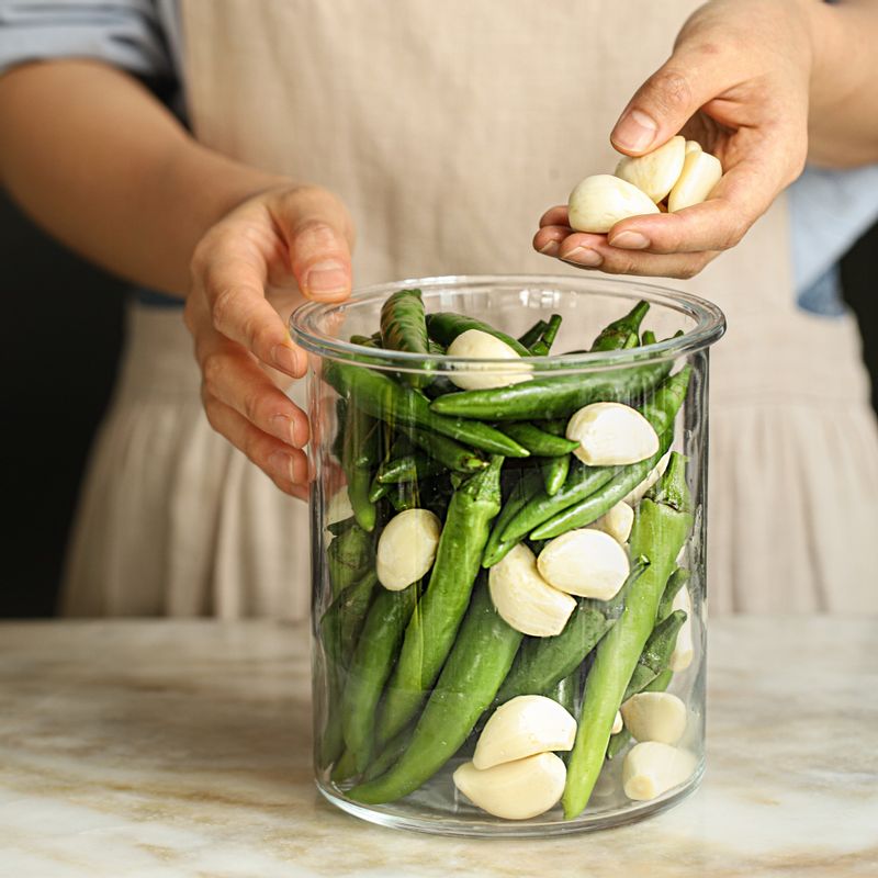 소독한 유리용기에 고추와 마늘을 담고 식힌 절임장을 부어주세요.
(고추가 절임장에서 뜨지 않도록 누름돌로 꼭 눌러 숙성해주세요.)