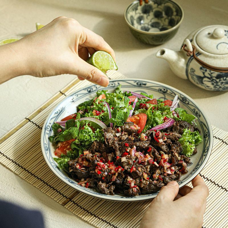접시에 쇠고기와 토마토,적양파, 치커리, 고수(또는 민트)를 먹기 좋게 담고 드레싱과 라임을 곁들여주세요.