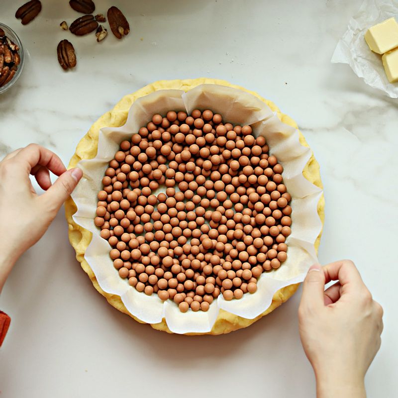 완성된 파이지에 유산지를 깔고 구움돌을 채워 170도에서 10분간 구운 후, 구움돌을 제거하고 다시 8분간 구워주세요.