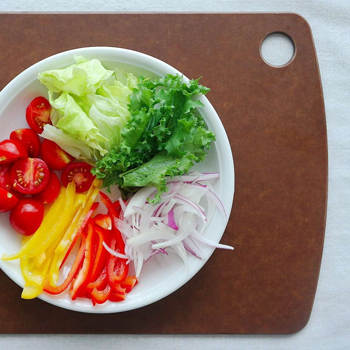 양상추와 치커리는 한입 크기로 뜯어주세요. 파프리카는 얇게 채를 썰고 방울토마토는 반으로 잘라주세요.