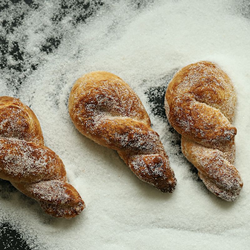 구워진 꽈배기의 절반은 뜨거울때 바로 설탕을 뿌려 골고루 묻혀 주세요. 나머지는 차갑게 식힌 후 생크림을 발라 카스테라 가루를 묻혀 완성해주세요.